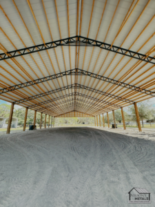 Private 60x120 pole barn interior revealing the sturdy roof and metal trusses.